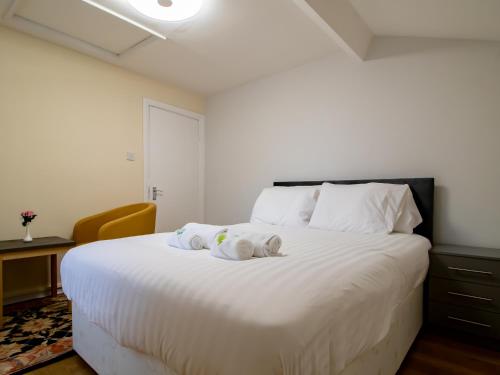a bedroom with a white bed with two stuffed animals on it at Spacious Well Equipped Flat - Pass the Keys in Gosforth
