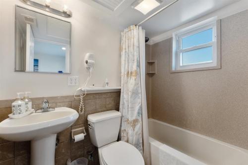 a bathroom with a sink and a toilet and a window at 415 E Atlanta Ave, Unit 107 in Wildwood Crest