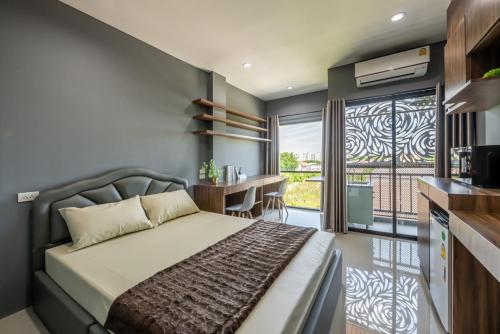 - une chambre avec un lit, un bureau et une fenêtre dans l'établissement พรรณวดี บูทีค เฮ้าส์, à Ban Bang Phang