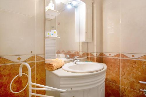 uma casa de banho com um lavatório e um espelho em A O - La Source em Peniche