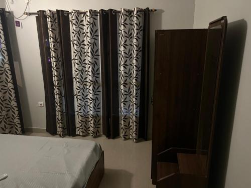 a bedroom with black and white curtains and a bed at Tani s Homestay in Bāruipur