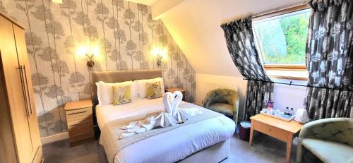 a bedroom with a bed and a desk and a window at Woodlands in Windermere
