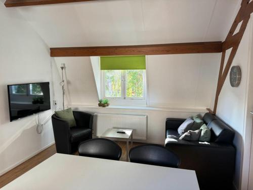 una pequeña sala de estar con 2 sillas y una mesa. en Short Stay Wageningen, en Wageningen