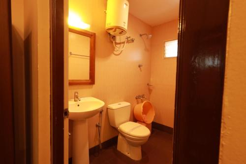 a small bathroom with a toilet and a sink at Hotel Nakshatra Inn VL Tuticorin in Tuticorin