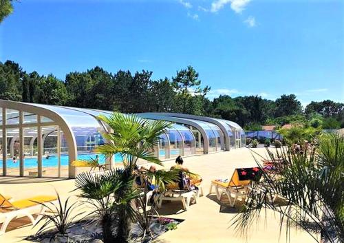 - un complexe avec une piscine et des chaises dans l'établissement Bungalow charmant à Saint-Jean-de-Monts avec piscine privée, à Saint-Jean-de-Monts