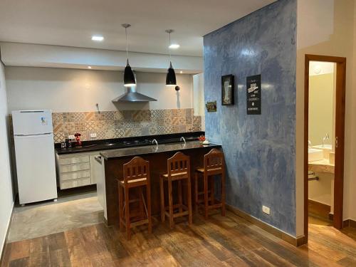 uma cozinha com um frigorífico e um balcão com bancos em Casa com ótima localização em São Sebastião