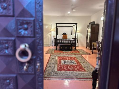 een kamer met een slaapkamer met een bed en een tapijt bij Anandmai Heritage Homestay in Jaipur