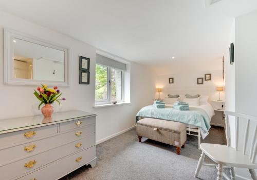 a bedroom with a bed and a dresser with a mirror at The Stable in Trentishoe