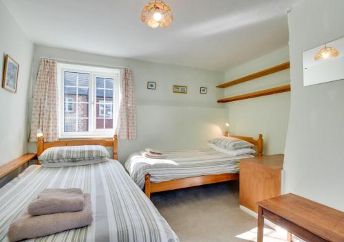 a bedroom with two beds and a window at The Malt House in Colyton