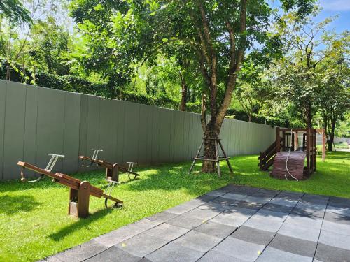 a playground with a tree and a fence at Mountain View Suite at The Valley Khaoyai in Ban Huai Sok Noi
