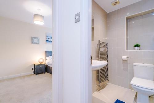 a bathroom with a toilet and a sink at 5 bed detached - Worsley, Manchester in Worsley