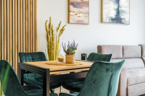 a dining room table with green chairs and a couch at Apartament Green Onyx przy plaży - Darmowy Parking in Sianozety