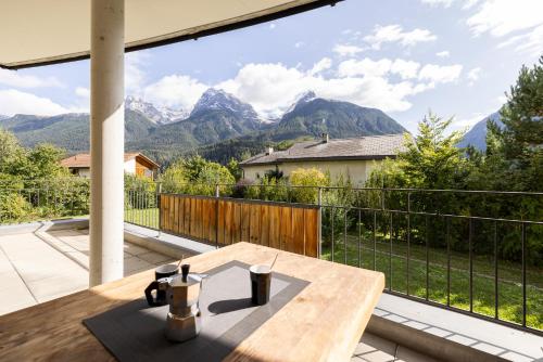 a wooden table on a balcony with a view of mountains at Trü-Sura Nr. 3 in Scuol