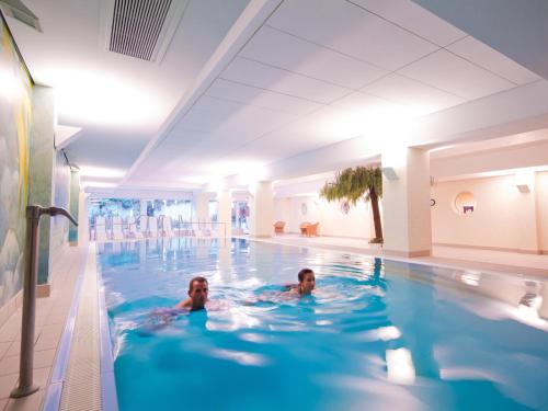 a person swimming in a swimming pool at Morada Resort Kühlungsborn in Kühlungsborn