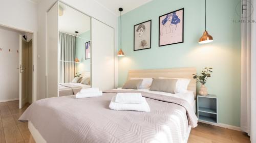 a bedroom with a large bed with two towels on it at City Center SPA Apartments Jaglana 6E,F in Gdańsk