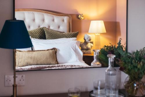 a mirror reflecting a bed with a bust on a table at Tŷ Afon - River House in Beddgelert