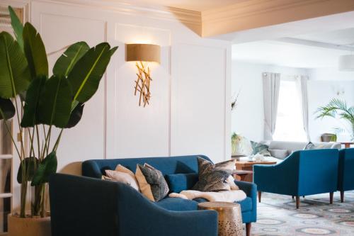 uma sala de estar com um sofá azul e cadeiras em Ty Afon - River House em Beddgelert