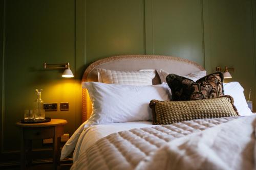 a bedroom with a bed with white sheets and pillows at Tŷ Afon - River House in Beddgelert