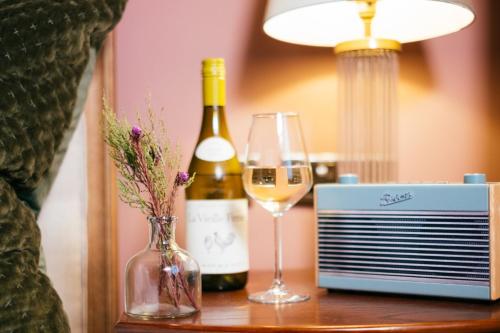 a bottle of wine and a glass on a table at Tŷ Afon - River House in Beddgelert