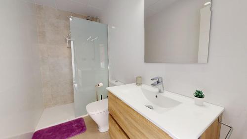 a bathroom with a sink and a toilet and a mirror at Villa Morera - A Murcia Holiday Rentals Property in Los Alcázares