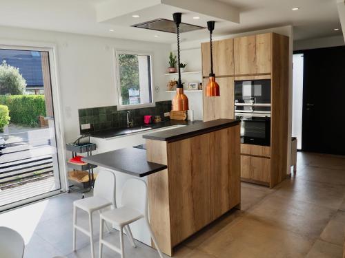 een keuken met een zwart aanrecht en witte apparaten bij Villa de prestige vue sur Baie de Canche in Le Touquet-Paris-Plage