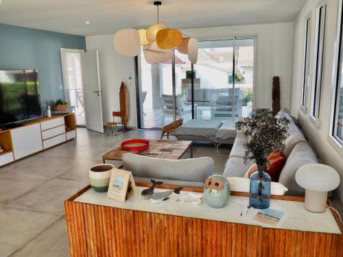een woonkamer met een bank en een tv bij Villa de prestige vue sur Baie de Canche in Le Touquet-Paris-Plage