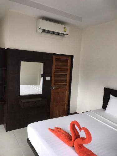 twee rode zwanen op een bed in een kamer bij Hassana Apartment in Krabi town