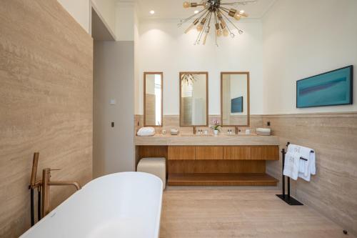 une salle de bain avec deux lavabos et un grand miroir dans l'établissement Appartement Avenue Montaigne - Paris Champs Elysées, à Paris