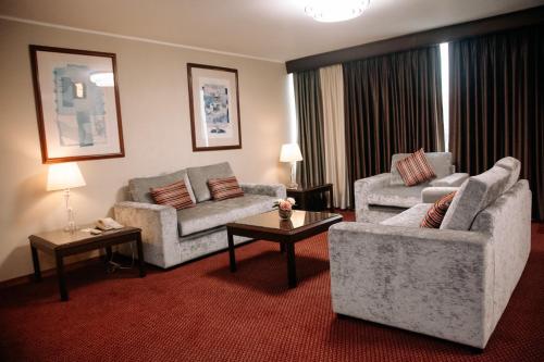a living room with two couches and two tables at Hotel Carrera in Lima