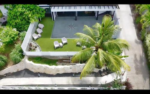 an aerial view of a house with a palm tree at GREEN LORD DOMAINE - Lodges Piscine & Spa - Bar & Lounge - Restaurant gastronomique in Lamentin