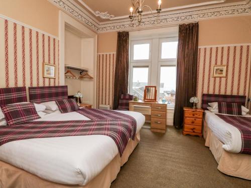 um quarto de hotel com duas camas e uma janela em Seaview Wellness Retreat em Carnoustie