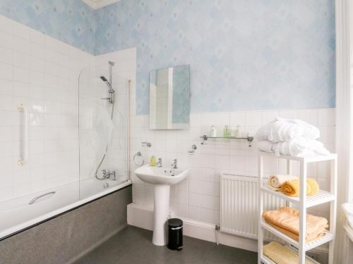 a white bathroom with a sink and a shower at Seaview Wellness Retreat in Carnoustie