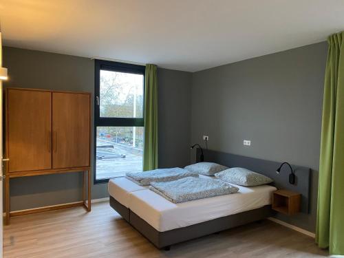 een slaapkamer met een bed en een groot raam bij Short Stay Wageningen in Wageningen