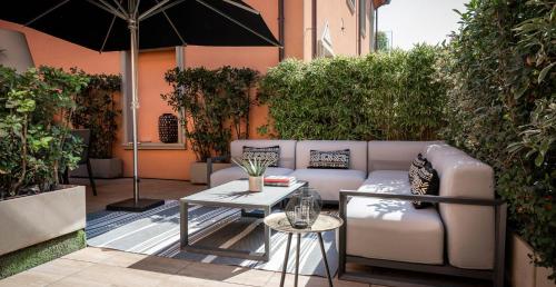 a patio with a couch and a table with an umbrella at Metropol Ceccarini Suite - Luxury apartments in Riccione