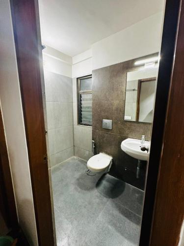 a bathroom with a sink and a toilet and a mirror at River Front Property in Ahmedabad