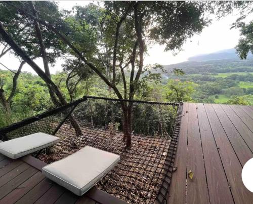 a wooden deck with two beds and a tree at Sweet Jungle Beach in Bejuco