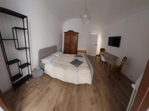 - une chambre avec un lit, un bureau et une télévision dans l'établissement GusterHouse, à Ivrea