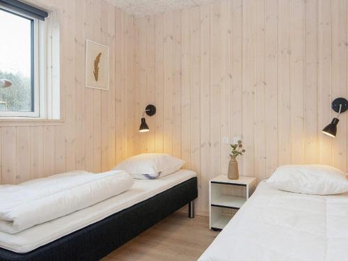 two beds in a room with wooden walls at Luxury Retreat with Pool - By Traum Ferienwohnungen in Kongsmark