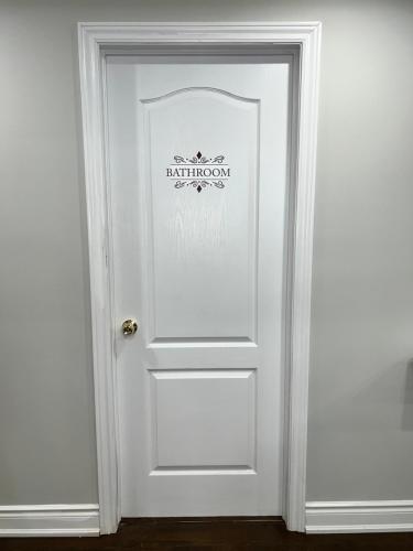 a white door with a sign on it at Tosam Luxury Lodge Two Bedroom Suite in Brampton