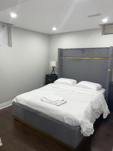 ein Schlafzimmer mit einem großen Bett mit weißer Bettwäsche in der Unterkunft Tosam Luxury Lodge Two Bedroom Suite in Brampton