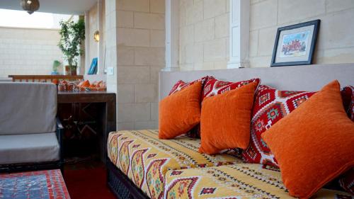 una cama con almohadas naranjas en una habitación en RIAD KALE POLIS en Marrakech