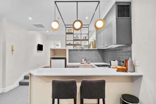 a kitchen with a counter and two chairs in it at Studio In Prime CBD Location in Sydney