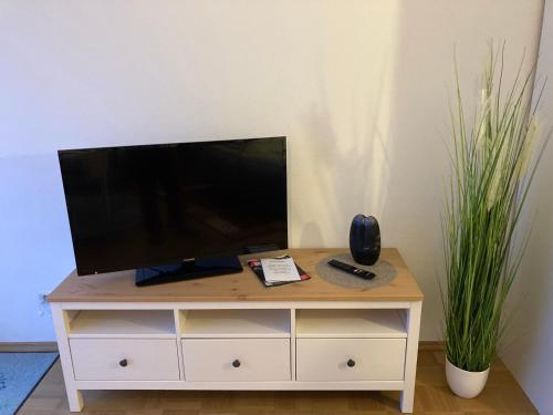 a television on a dresser with a remote control on it at Apartment Renz in Freudenstadt