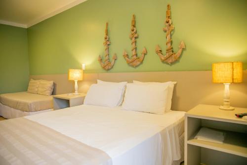 um quarto com uma grande cama branca e 2 candeeiros em Pousada Villa Di Enzo em Ubatuba