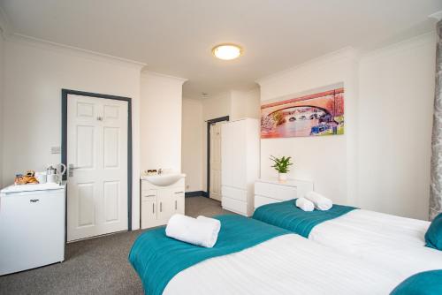 a bedroom with two beds and a sink at Wilson Lodge in Maidenhead