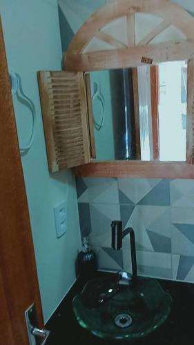 a bathroom with a green sink and a mirror at Segunda Casa- Seu cantinho na Praia do Morro em Guarapari - Quartos suítes 2 até 4 pessoas in Guarapari