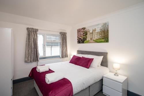 a bedroom with a large white bed and a window at Wilson Lodge in Maidenhead