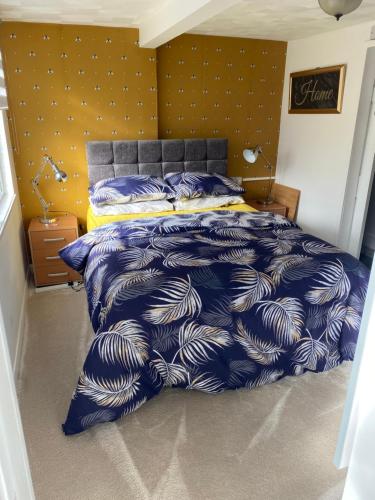 a bedroom with a bed with a blue and white comforter at The Hideaway!! Skegness ground floor room free parking in Skegness