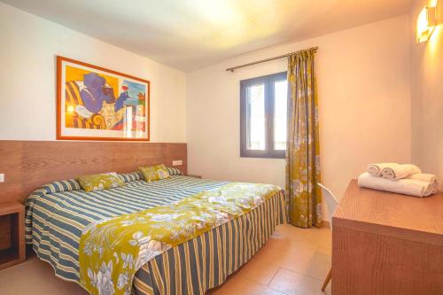 a bedroom with a large bed and a window at Vibra Blanc Cottage Apartmentos - 3SUP in Sa Caleta
