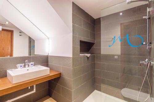 La salle de bains est pourvue d'un lavabo et d'une douche. dans l'établissement Vibra Blanc Cottage Apartmentos - 3SUP, à Sa Caleta